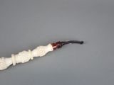 a pipe with a carved handle on a gray surface