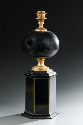 une photo d'une lampe de table noire et dorée posée sur un socle