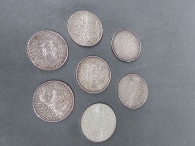 six types de pièces différents disposés en cercle sur une surface grise