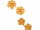 a close up of three gold flowers on a white background