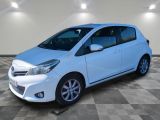 a white toyota yaris parked in a room with a checkered floor