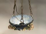 a close up of a bird feeder hanging from a chain