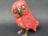 a small red bird that is sitting on a table