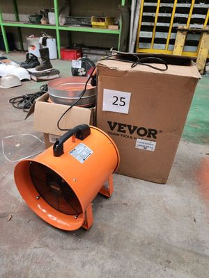 un souffleur orange posé par terre à côté d'une boîte