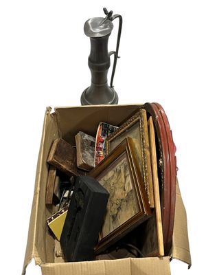 a cardboard box full of assorted items and a lamp