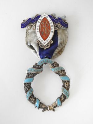 an image of a silver and blue broochle with a ribbon around it