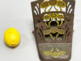 a yellow lemon sitting next to a metal holder with a mirror