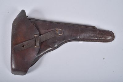 une vieille chaussure en cuir marron avec une lanière en cuir sur un fond blanc