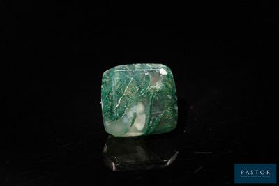 an image of a green and white stone sitting on top of a black surface