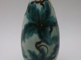 un vase bleu et blanc posé sur une surface blanche