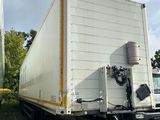 un camion blanc garé sur un parking à côté d'un immeuble