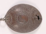 a silver plate with a bird on it on a white surface