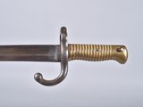 a close up of a sword on a white surface