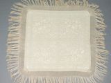 une image représentant une nappe blanche ornée de franges