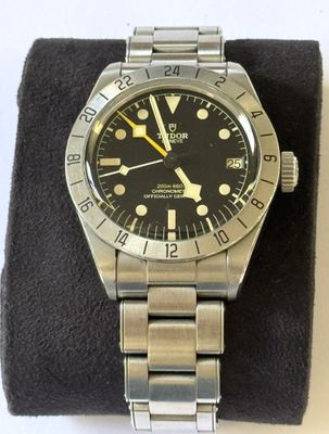 une photo d'une montre Rolex avec un cadran noir et des aiguilles jaunes