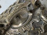 a close up of a silver plate with a bird on it
