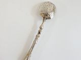 silver plated spoon on a white table with a white background