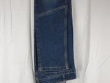 denim pants hanging on a clothes rack on a white sheet