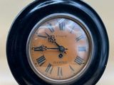 une horloge noire avec des chiffres romains