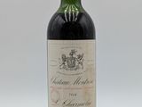 une vieille bouteille de vin posée sur une table blanche