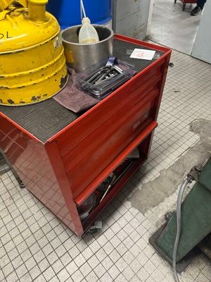une borne d'incendie jaune posée sur un chariot rouge