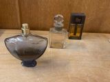 bottles of perfume sitting on a table with a box of perfume in the background
