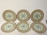 six assiettes ornées de motifs, posées sur une surface blanche