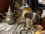 a table with a lot of silver and gold items on it