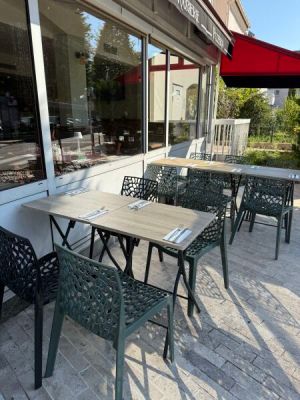 tables and chairs outside of a restaurant with a red umbrella
