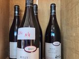 three bottles of red wine sit on a shelf in a wooden box