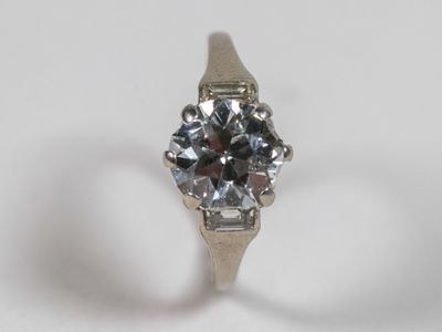 une image d'une bague en diamant sur une surface blanche