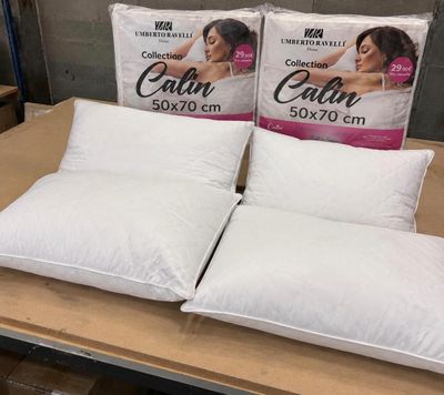 deux oreillers blancs posés l'un à côté de l'autre sur une table en bois