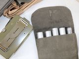 a wallet with four pens in it sitting on a table