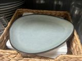 a wicker basket with plates and bowls in it