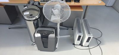 a fan sitting next to a desk with a computer on it