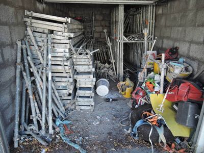 un tas de bric-à-brac dans un garage, à côté d'un tas d'outils