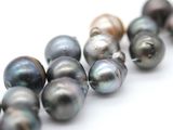 a lot of different colored pearls on a white surface
