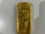 a close up of a gold bar on a white surface