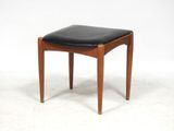 a wooden stool with black leather seat on a white background