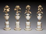quatre vases blancs ornés de bordures dorées et décorés de fleurs