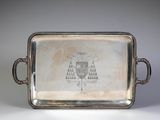 an old silver tray with a drawing on it sitting on a table