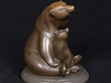 bronze sculpture of a bear holding a cub on a black background