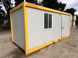 a yellow and white container sitting on top of a dirt field