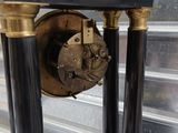 a black and gold clock on a black stand