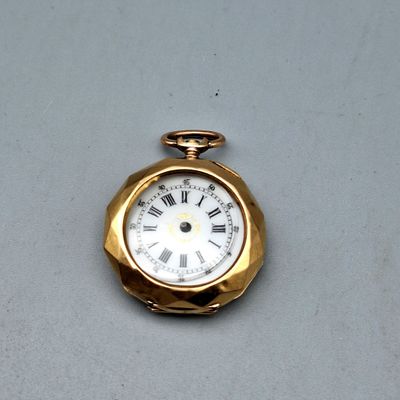 une montre de poche en or avec des chiffres romains