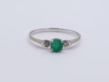 an emerald and diamond ring on a white background