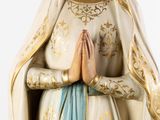 a statue of a woman with her hands folded in prayer