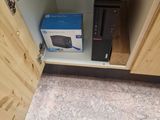 a computer in the corner of a cabinet with a box on it