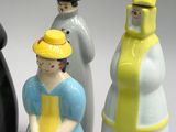 three salt and pepper shakers in the shape of women