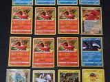 il y a beaucoup de cartes Pokémon sur la table, dont un grand nombre